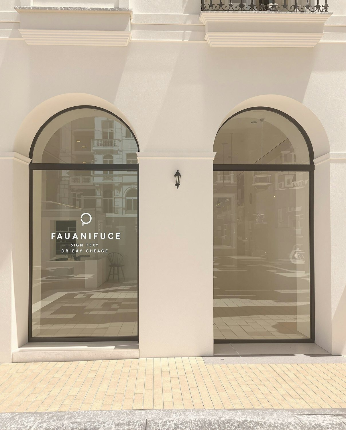 Elegant cream shopfront with arched windows and reflective glass