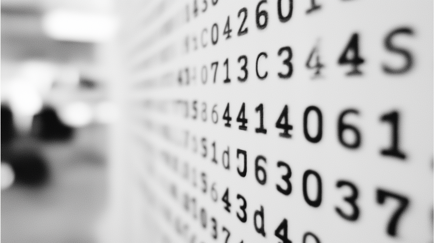 Black and white close-up of bold letters and numbers on a wall